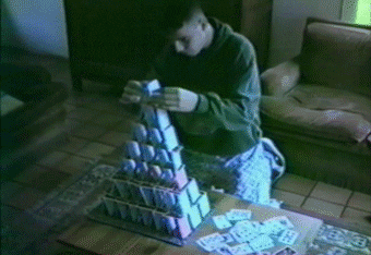 Giphy: Man building house of cards and cat knocks it over