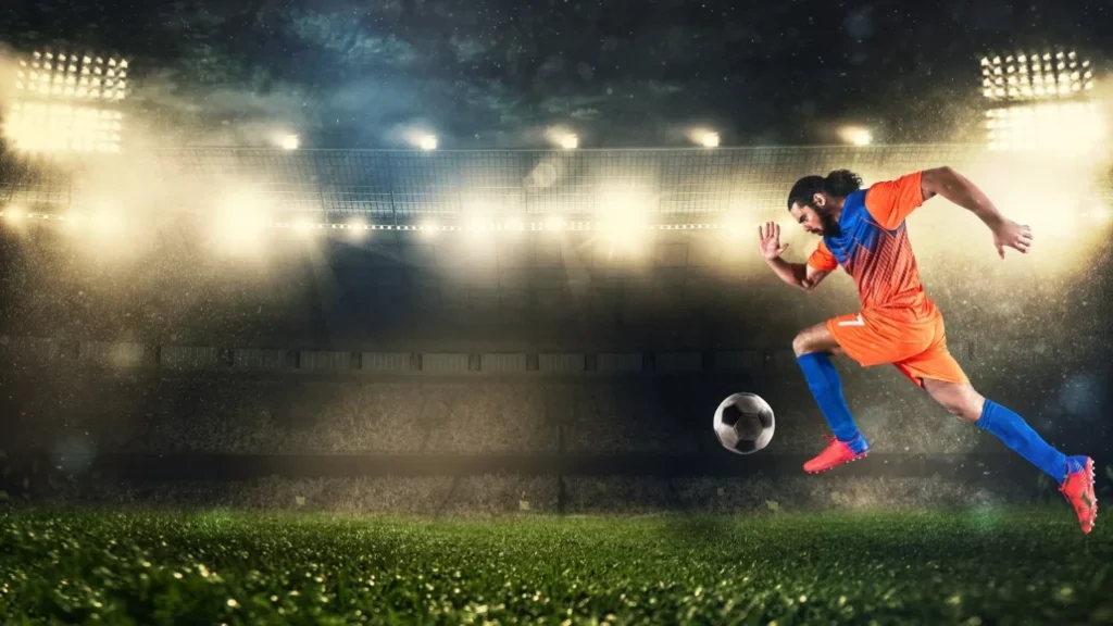 a soccer player kicking a ball down a pitch 